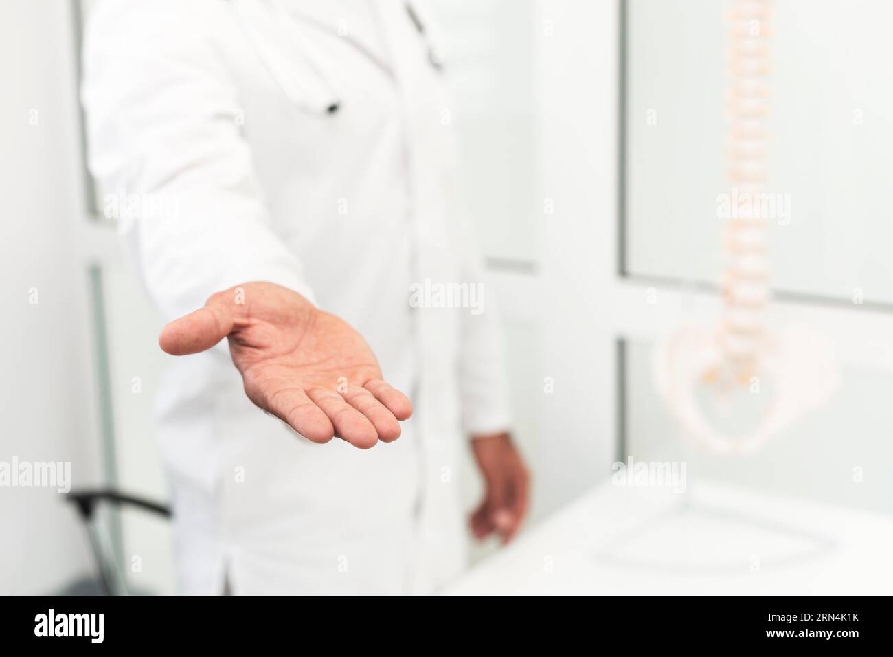 Männlicher Arzt, der seine Hand anbietet Stockfoto