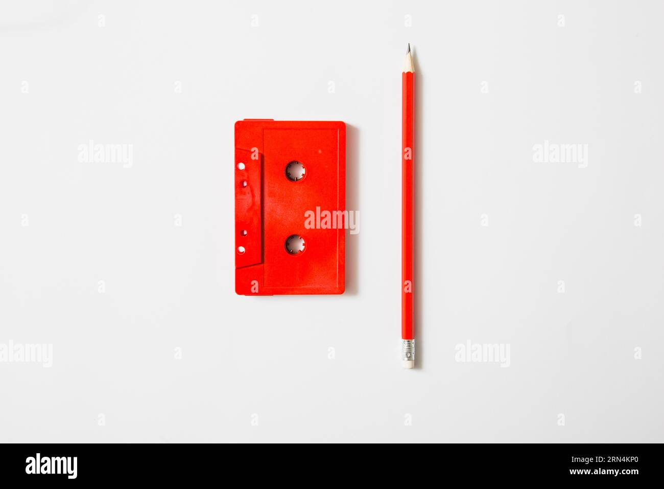Roter Kassettenstreifen, Bleistift, weißer Hintergrund Stockfoto