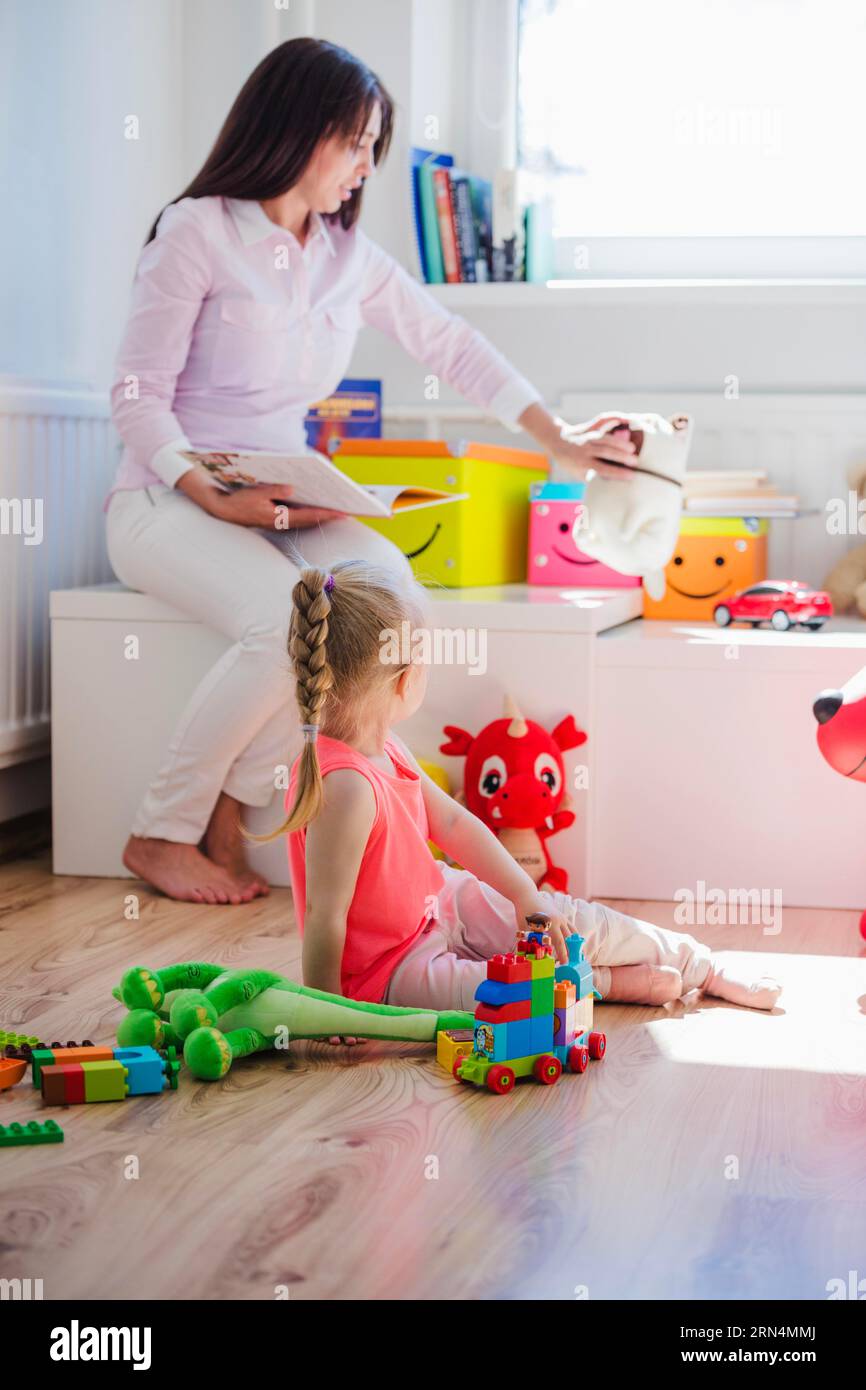 Frau spielt mit Kinderspielzimmer Stockfoto