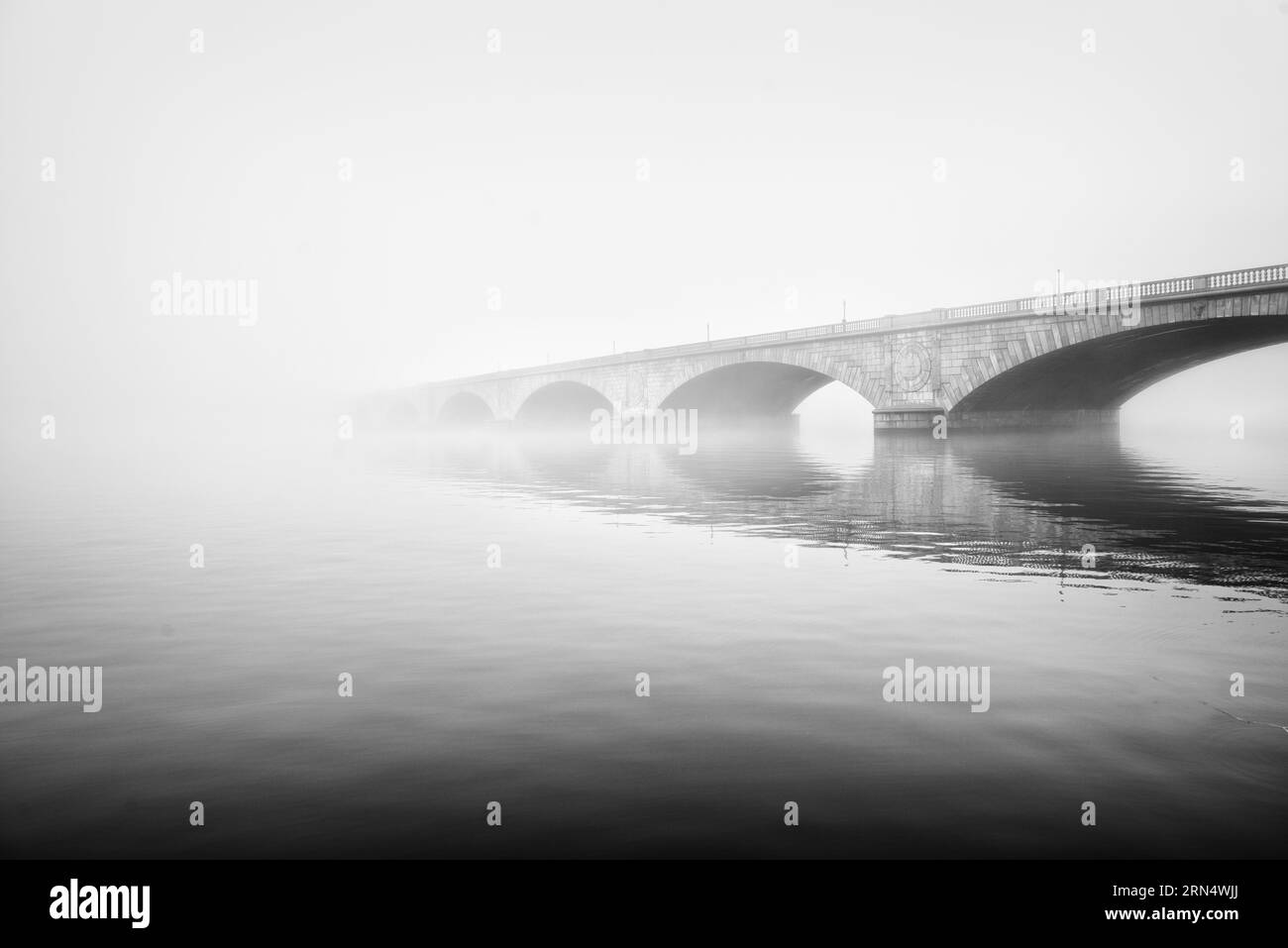 Memorial Bridge in Fog, Washington, D.C. Schwarzweißfoto, das die Bögen der Brücke zeigt, die teilweise von Nebel über dem Wasser verdeckt sind. Stockfoto