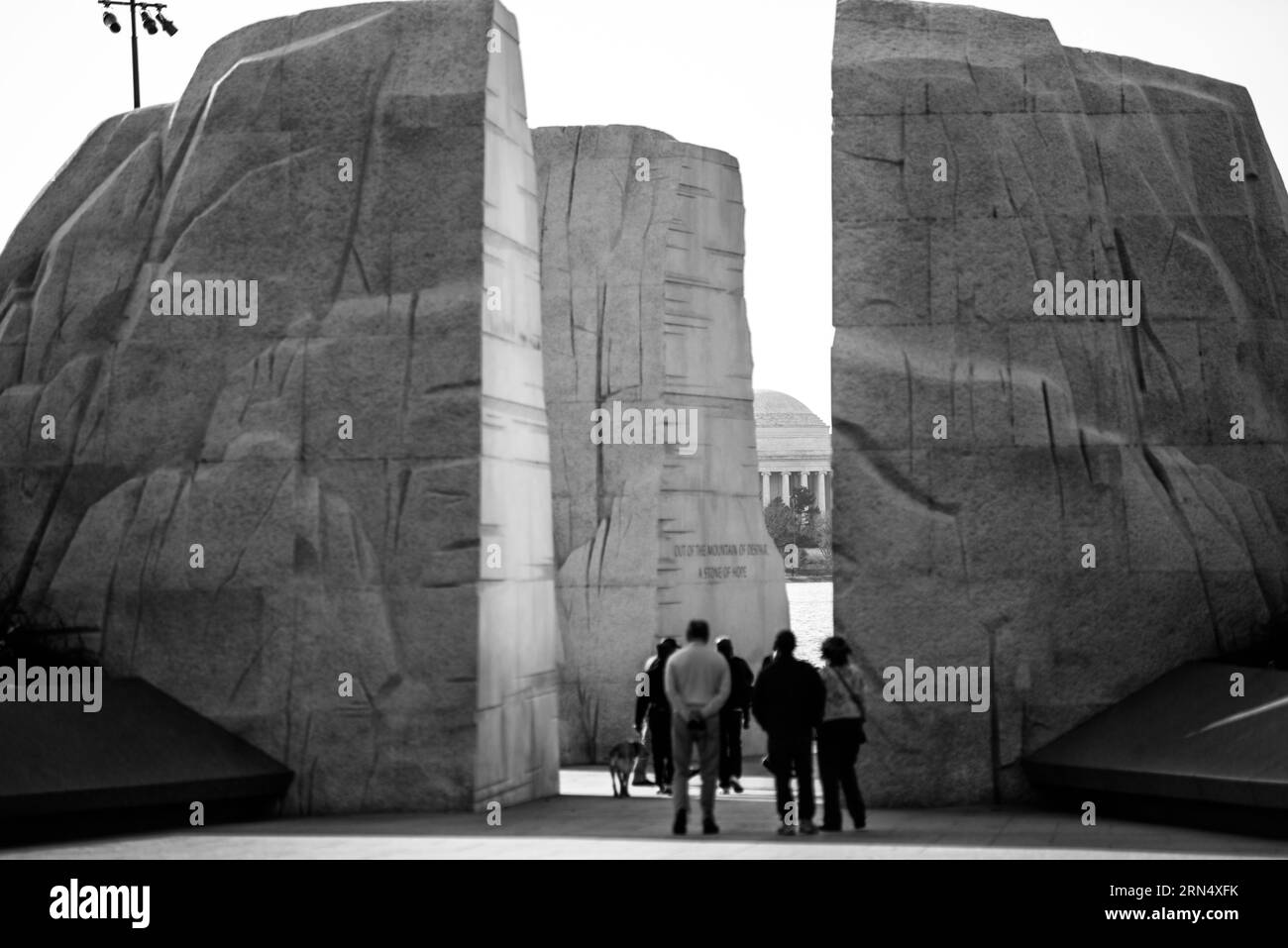 Martin Luther King Jr. Memorial, Washington, D.C. Schwarzweißfoto, das das Denkmal mit Touristen im Vordergrund zeigt, und das Jefferson Memorial, das in der Ferne sichtbar ist. Stockfoto
