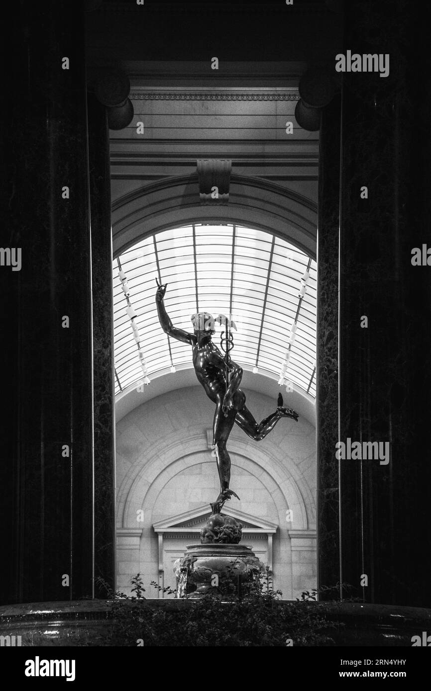 Quecksilberstatue, National Gallery of Art, Washington, D.C. Schwarzweißfoto zeigt die Statue eingerahmt von Säulen und einem großen bogenförmigen Fenster. Stockfoto