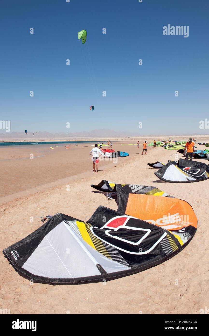 Kitesegel liegen am Strand am Roten Meer, Kitesurfer im Hintergrund, Soma Bay, Ägypten Stockfoto