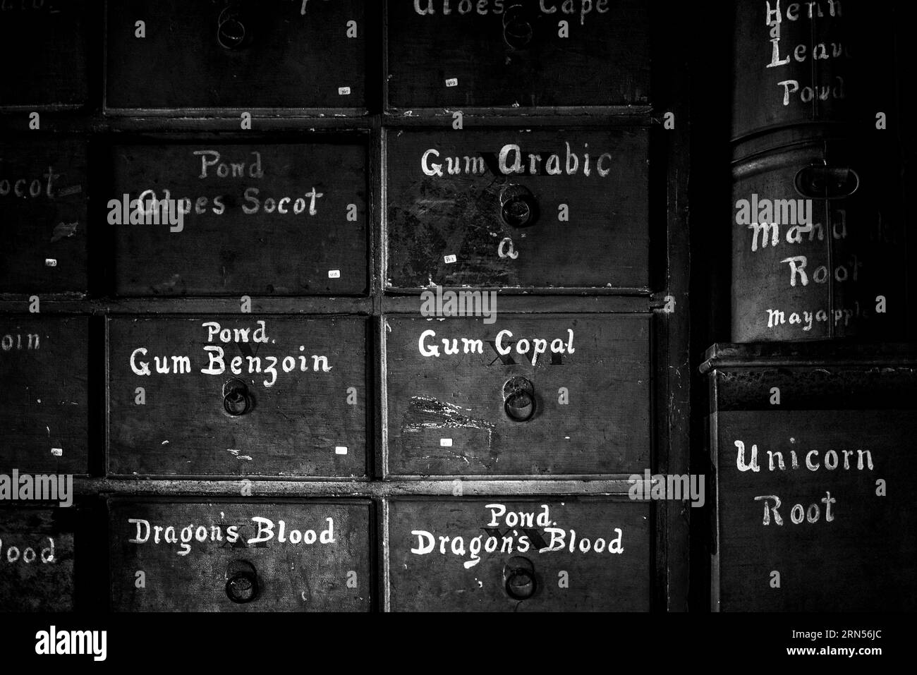 Medizinschubladen, Stabler-Leadbeater Apothecary Museum, Alexandria. Schwarzweiß-Foto mit beschrifteten Schubladen und Behältern mit sichtbarem Verschleiß. Stockfoto