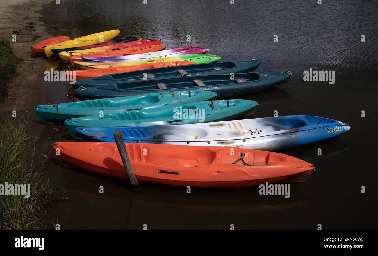 Bunte Boote, Kanus, die auf dem Lac Chambon, dem Vulkansee, Chambon-sur-Lac, dem Departement Puy-de-Dome, der Region Auvergne-Rhone-Alpes liegen, Frankreich Stockfoto