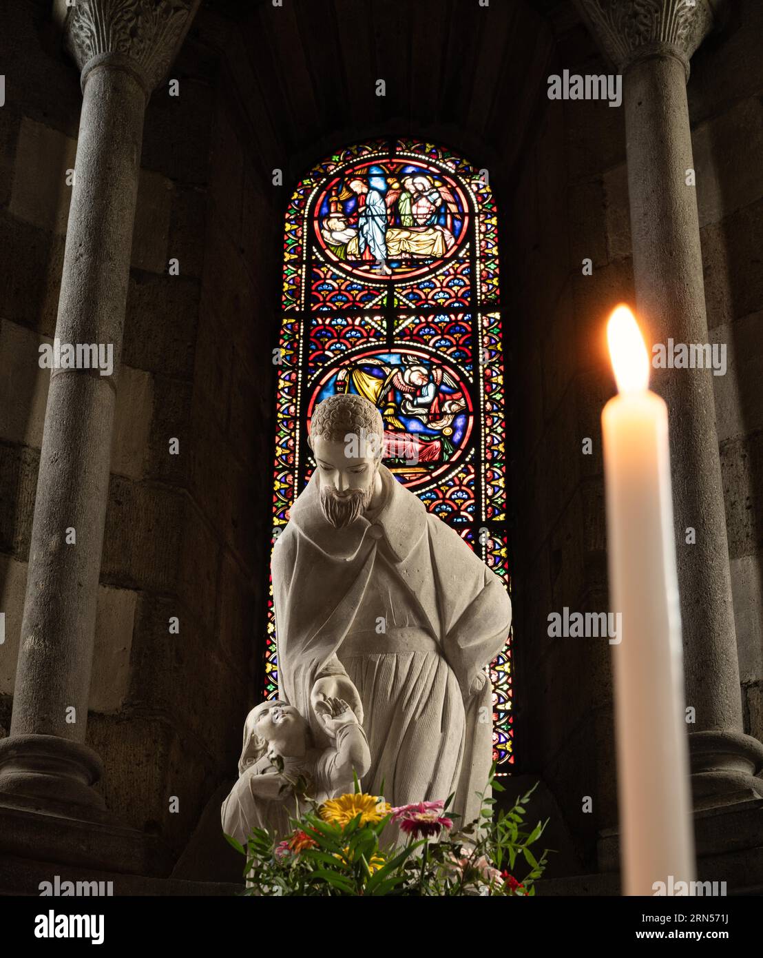 Innenaufnahme der heiligen Figur vor Buntglasfenster, Kerze, Kirche Saint Joseph, La Bourboule, Puy-de-Dome Departement Stockfoto Innenaufnahme der heiligen Figur vor Buntglasfenster, Kerze, Kirche Saint Joseph, La Bourboule, Puy-de-Dome Departement Stockfoto
