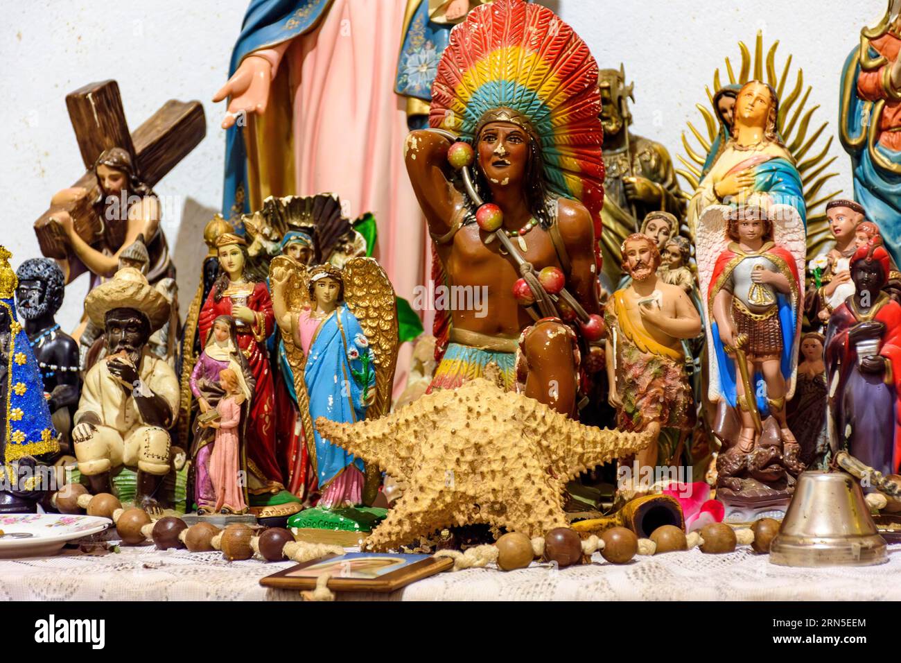 Altar mit mehreren Bildern von Heiligen, Wesenheiten afrikanischer Herkunft wie Umbanda und Candomble und Alltagsgegenstände in einem gut Stockfoto