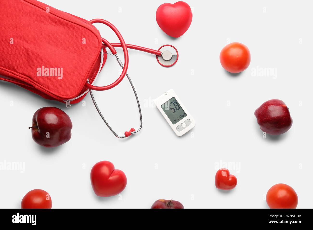 Zusammensetzung mit Glucometer, Stethoskop, roten Herzen und frischen Äpfeln auf weißem Hintergrund. Diabetes-Konzept Stockfoto