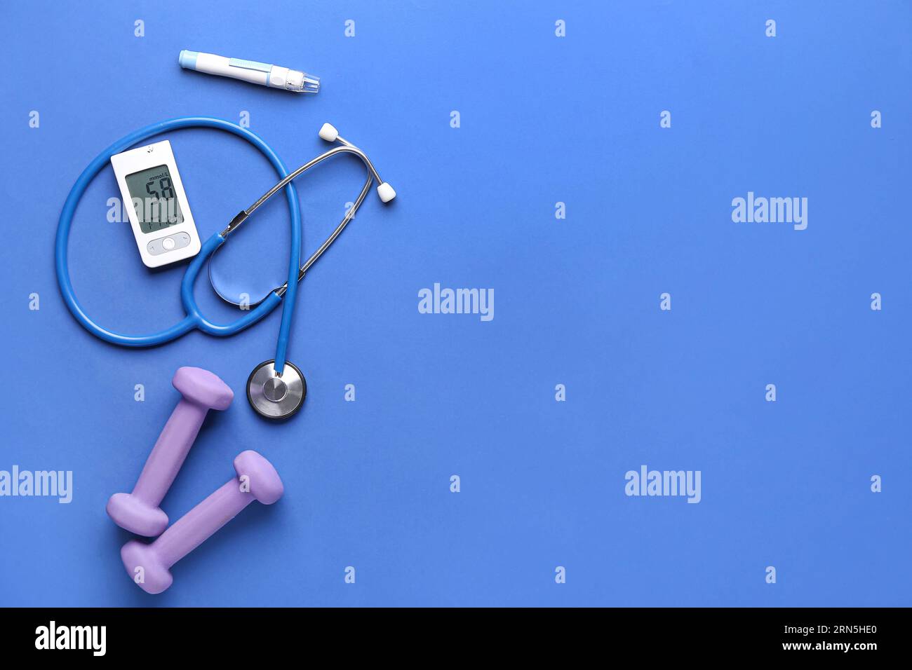 Glucometer, Kurzhanteln, Lanzette und Stethoskop auf blauem Hintergrund. Diabetes-Konzept Stockfoto