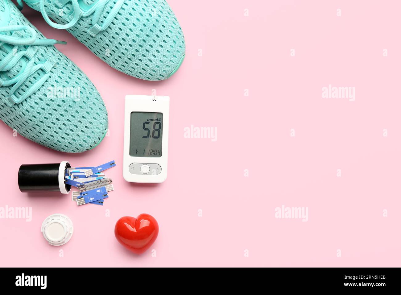 Glucometer mit Ergebnis der Zuckerspiegelmessung, Sneakers und Skarifikatoren auf rosa Hintergrund. Diabetes-Konzept Stockfoto