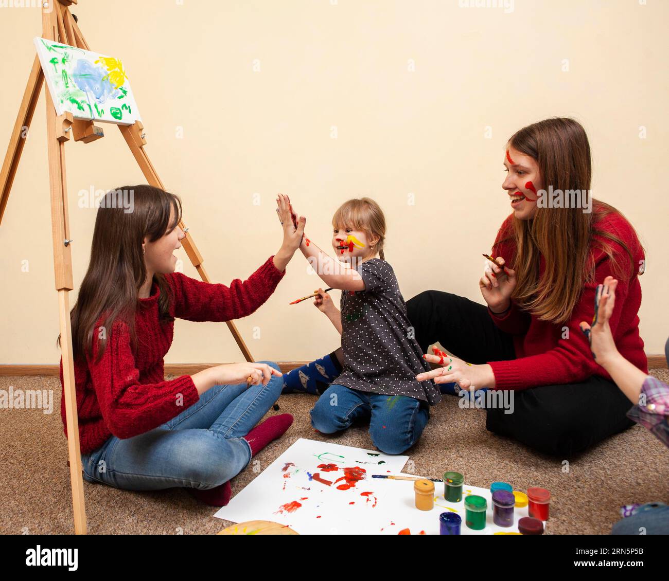 Mädchen mit Down-Syndrom High Fünfer beim Malen Stockfoto