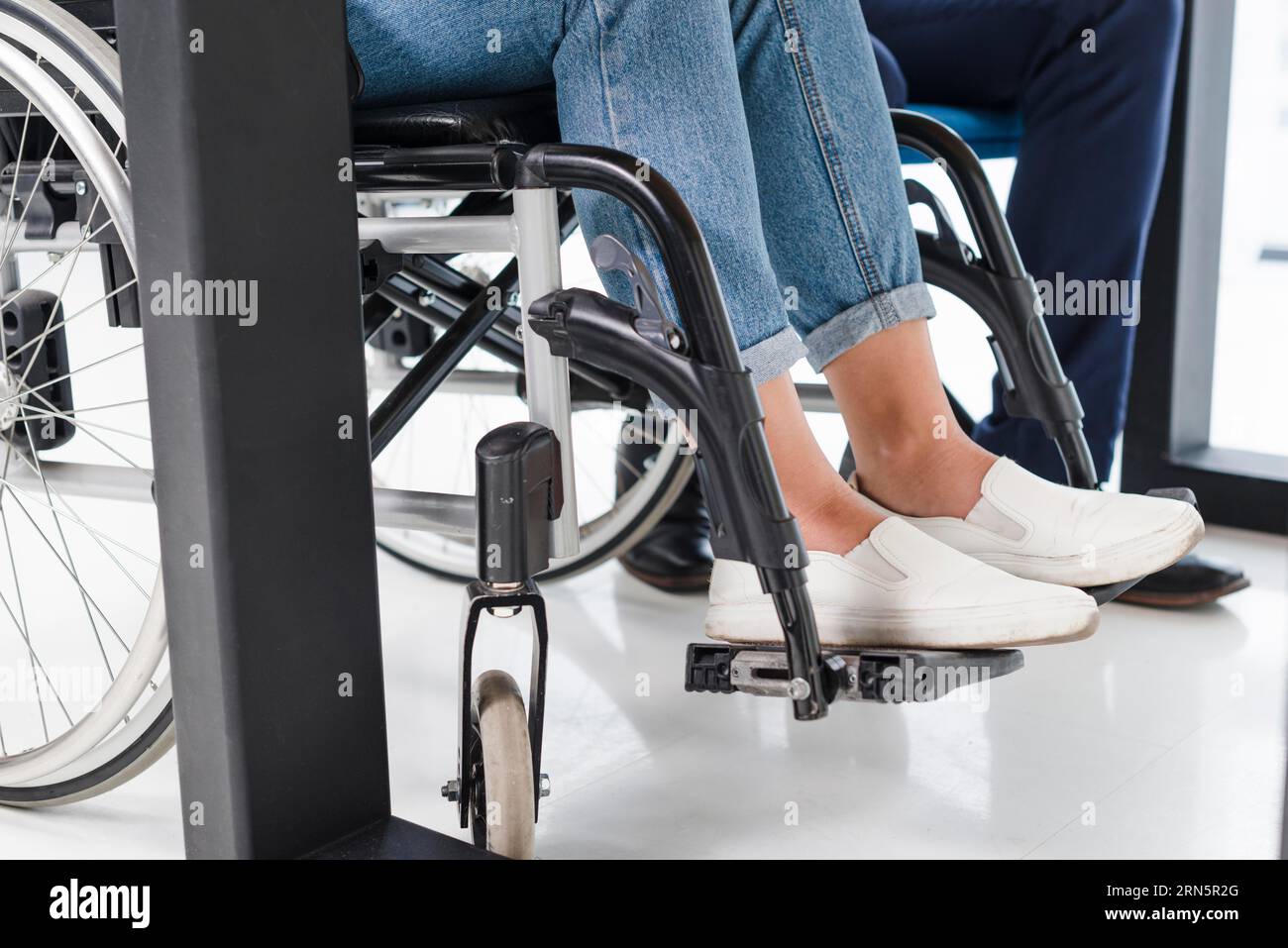 Behinderte Frauen Füße Rollstuhl weißen Boden Stockfoto