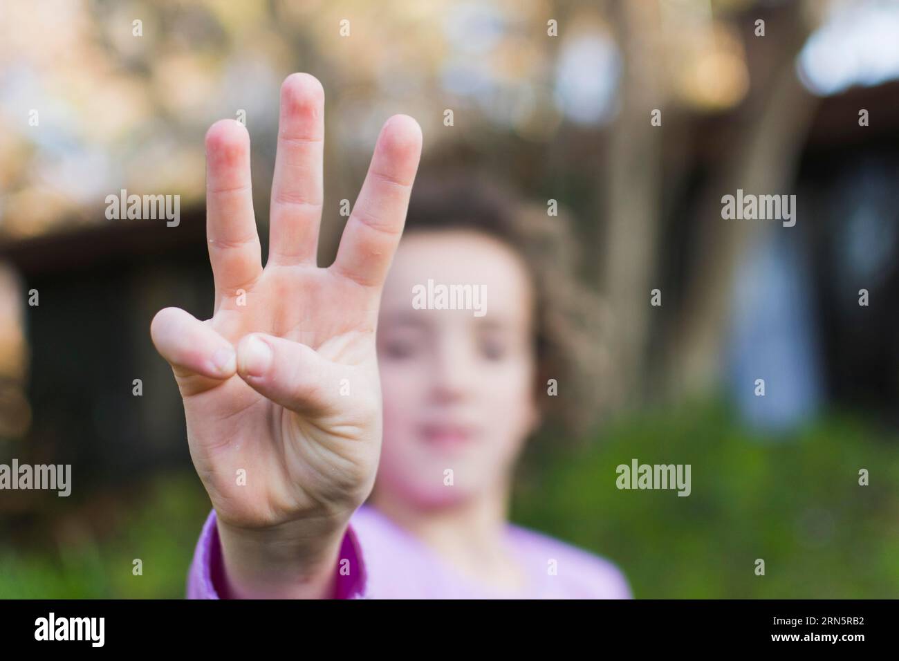 Mädchen mit drei Fingern grüßt die Handbewegung Stockfoto