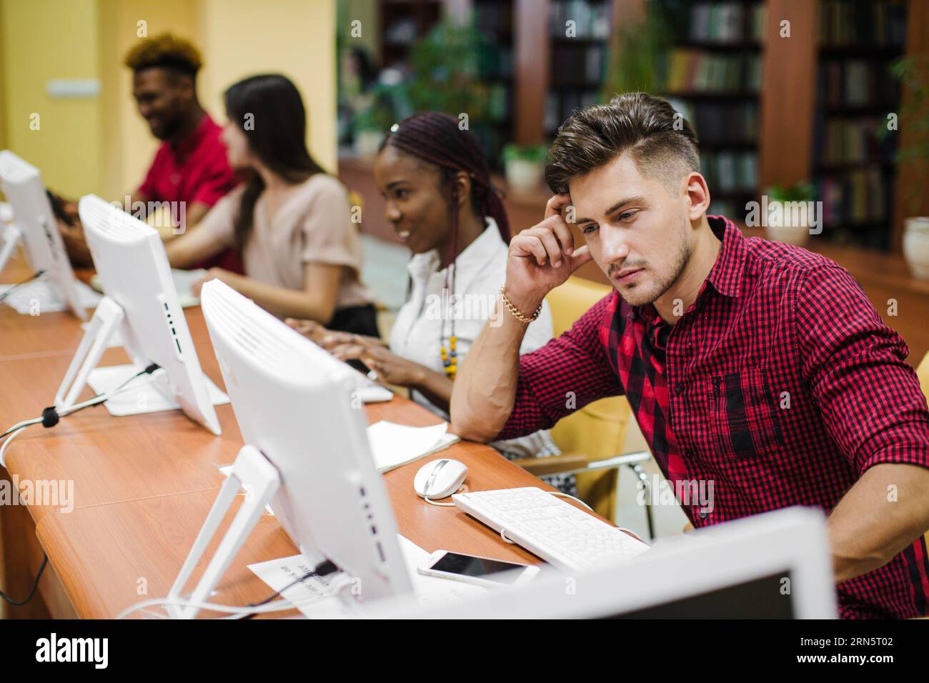 Nachdenklicher Mann im Klassenzimmer mit Computern Stockfoto