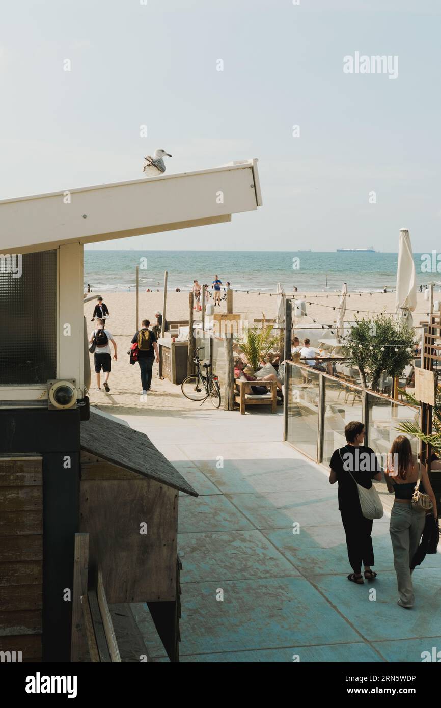 Leute, die am dutch Scheveningen Strand in der Nähe von Restaurants spazieren gehen Stockfoto