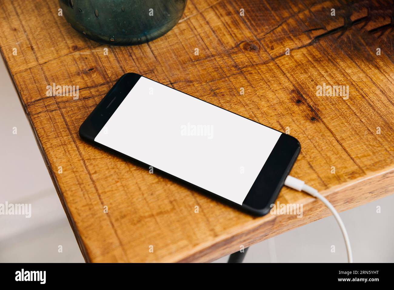 Smartphone mit weißem Bildschirm, Holztisch Stockfoto