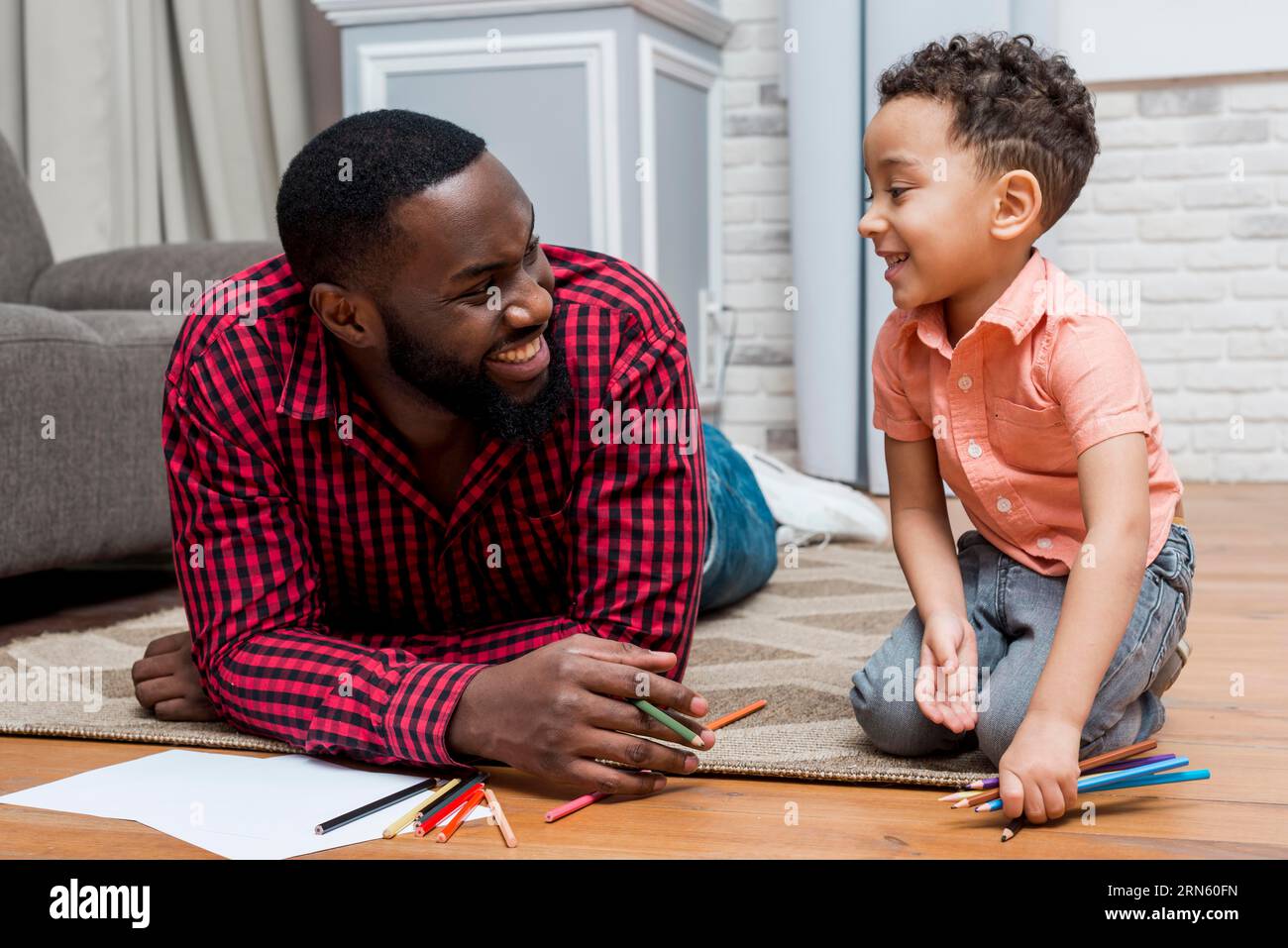 Schwarzer Vater Sohn mit Bleistiftboden Stockfoto