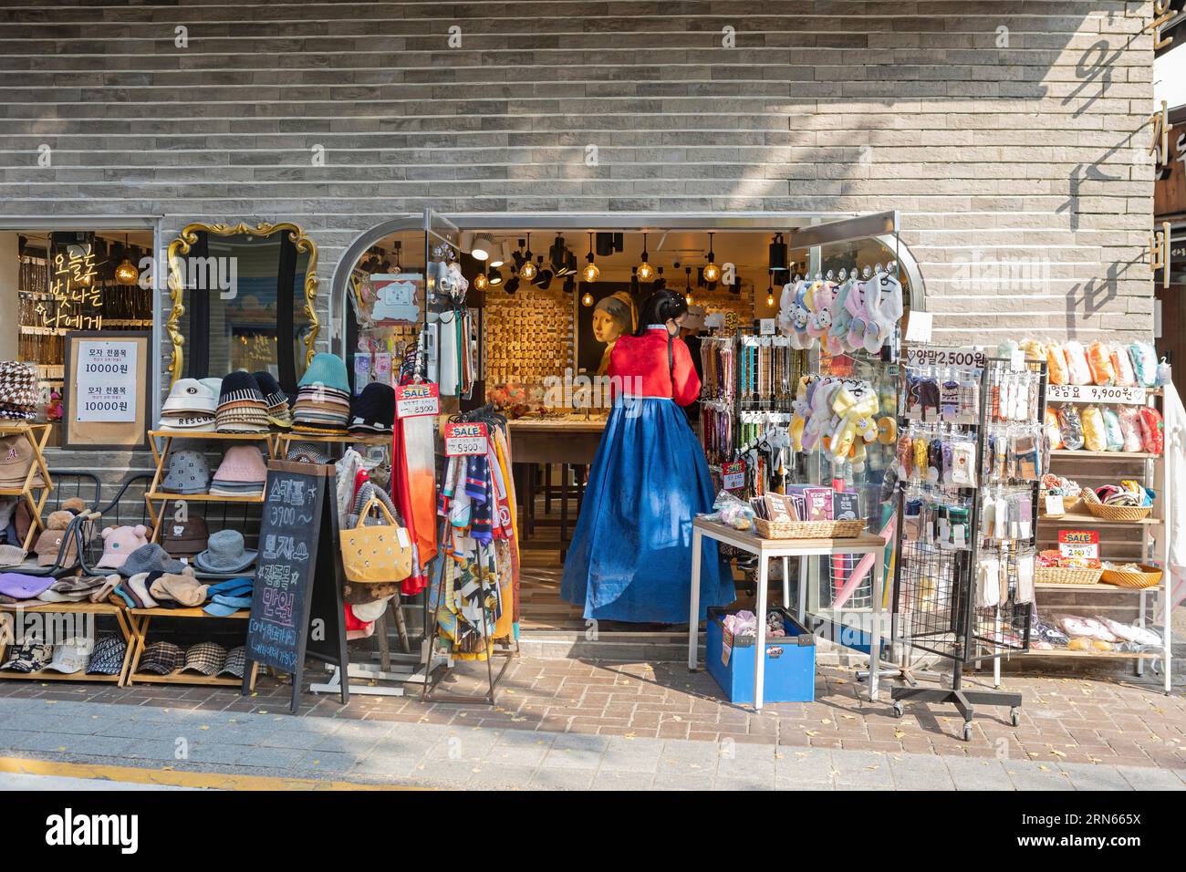 Junge Frau in traditionellem Hanbok, die in einem Souvenirladen in der Nähe des Dorfes Bukchon Hanok, Jongno-gu, Seoul steht Stockfoto