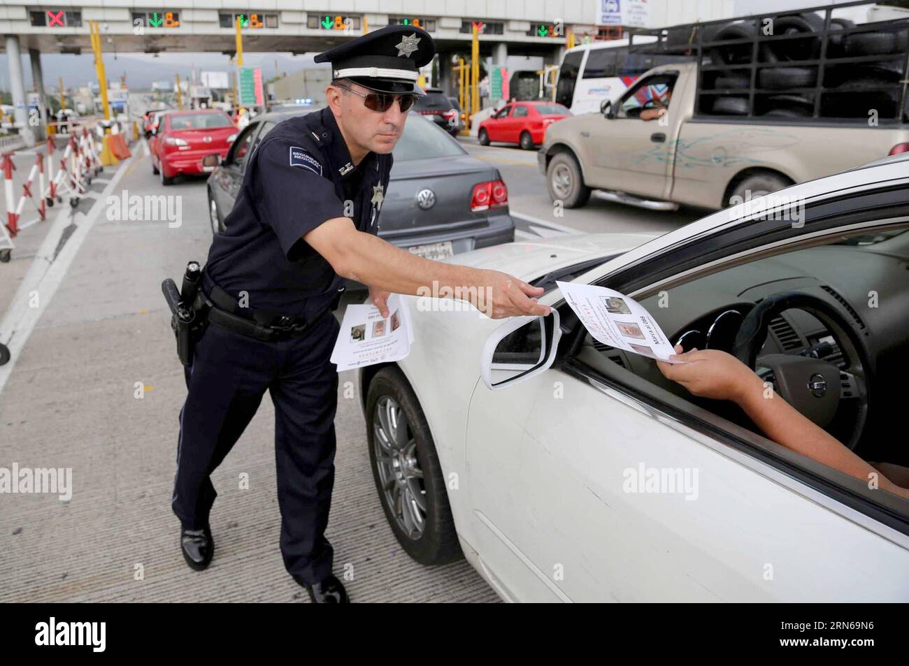 AKTUELLES ZEITGESCHEHEN Mexiko: Suche nach Joaquin El Chapo Guzman (150716) -- CHALCO, 16. Juli 2015 -- Bild bereitgestellt am 16. Juli 2015 von der Allgemeinen Kommunikationsleitung des mexikanischen Scretariats des Innern (), zeigt eine Polizei, die einem Fahrer ein Flugblatt über Mexikos Drogenlord Joaquin El Chapo Guzman an der Mautstelle von San Marcos auf dem Mexico-Puebla Highway in Chalco, Mexiko, aushändigt. In einem am Mittwoch veröffentlichten Bericht teilte die mit, dass sie 101 Revisionsfilter eingerichtet hat, die sich auf den Hauptstraßen und Bundesstraßen im ganzen Land befinden, und dass es eine Warnung bei Ai gibt Stockfoto