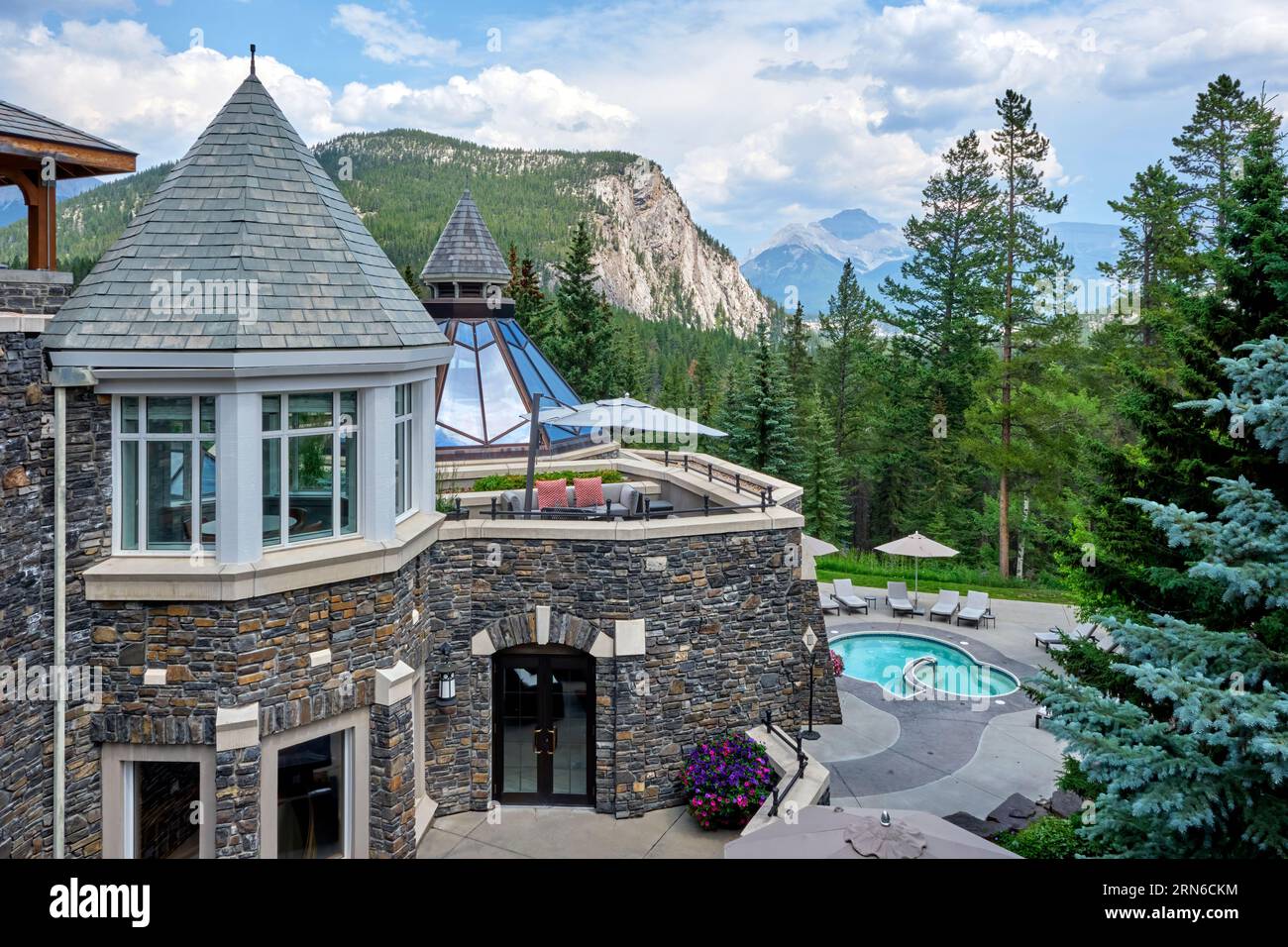 Eine Terrasse und ein Poolbereich im Fairmont Banff Springs Hotel mit einem herrlichen Blick auf die Rocky Mountains. Stockfoto