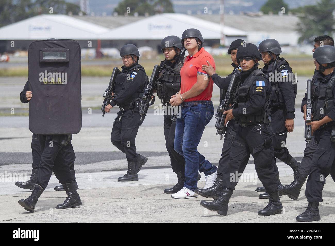 Mitglieder der Sicherheitskräfte begleiten den mutmaßlichen Drogenhändler Jairo Estuardo Orellana(C) während seiner Auslieferung in den Einrichtungen der guatemaltekischen Luftwaffe in Guatemala City, der Hauptstadt von Guatemala, am 24. Juli 2015. Der mutmaßliche Drogenhändler Jairo Estuardo Orellana wurde in die Vereinigten Staaten ausgeliefert und steht vor der Anklage als Hauptlieferant von Kokain des mexikanischen Drogenkartells Los Zetas und Verschwörung für den Drogenhandel in Richtung amerikanisches Territorium. Luis Echeverria) (jg) GUATEMALA-GUATEMALA CITY-SECURITY-EXTRADITION e LuisxEcheverria PUBLICATIONxNOTxINxCHN Security Forces Members Escort Stockfoto