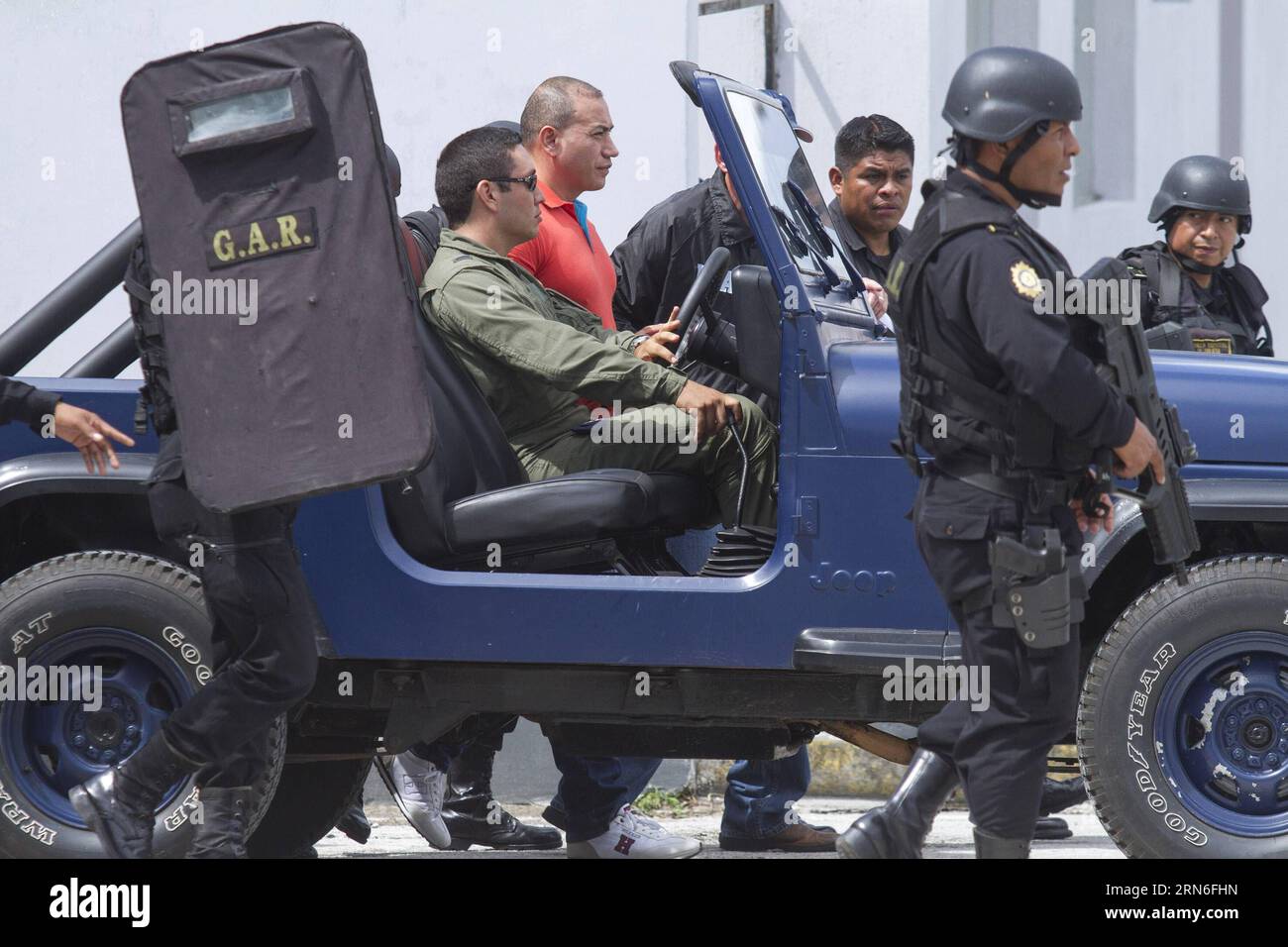 Mitglieder der Sicherheitskräfte begleiten den mutmaßlichen Drogenhändler Jairo Estuardo Orellana (C, zurück) während seiner Auslieferung in den Einrichtungen der guatemaltekischen Luftwaffe in Guatemala City, Hauptstadt von Guatemala, am 24. Juli 2015. Der mutmaßliche Drogenhändler Jairo Estuardo Orellana wurde in die Vereinigten Staaten ausgeliefert und steht vor der Anklage als Hauptlieferant von Kokain des mexikanischen Drogenkartells Los Zetas und Verschwörung für den Drogenhandel in Richtung amerikanisches Territorium. Luis Echeverria) (jg) GUATEMALA-GUATEMALA-STADT-SICHERHEITS-AUSLIEFERUNG und LuisxEcheverria PUBLICATIONxNOTxINxCHN Sicherheitskräfte Mitglieder Stockfoto