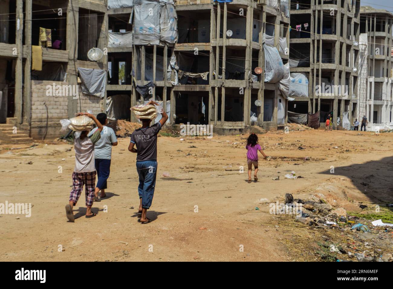 (150801) -- ALEPPO, 1. August 2015 -- vertriebene syrische Familien versammeln sich am 30. Juli 2015, um Hilfe von humanitären Organisationen im zerrütteten Bezirk Hamadaniyeh, Aleppo, Nordsyrien, zu sammeln. Aleppo, die größte Stadt Syriens und einst ein Wirtschaftszentrum, wurde zwischen den Rebellen im Osten und den Regierungstruppen in den westlichen Teilen der Stadt zerrissen, während Teile der nördlichen Landschaft unter der Kontrolle DES IS stehen. Die Aleppaner leiden unter Wasser- und Stromknappheit und schlechten sanitären Einrichtungen. SYRIEN-ALEPPO-VERTRIEBENE AbdxFayad PUBLICATIONxNOTxINxCHN 150801 Aleppo Stockfoto