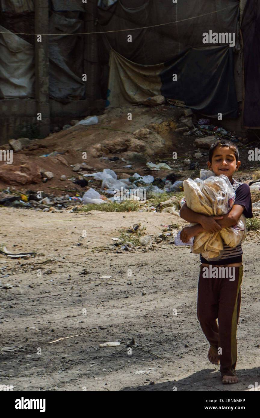 (150801) -- ALEPPO, 1. August 2015 -- Ein vertriebenes syrisches Kind lächelt, nachdem es am 30. Juli 2015 Nahrungsmittelhilfe von humanitären Organisationen im zerrütteten Bezirk Hamadaniyeh, Aleppo, Nordsyrien, erhalten hat. Aleppo, die größte Stadt Syriens und einst ein Wirtschaftszentrum, wurde zwischen den Rebellen im Osten und den Regierungstruppen in den westlichen Teilen der Stadt zerrissen, während Teile der nördlichen Landschaft unter der Kontrolle DES IS stehen. Die Aleppaner leiden unter Wasser- und Stromknappheit und schlechten sanitären Einrichtungen. SYRIEN-ALEPPO-VERTRIEBENE AbdxFayad PUBLICATIONxNOTxINxCHN 150801 Stockfoto