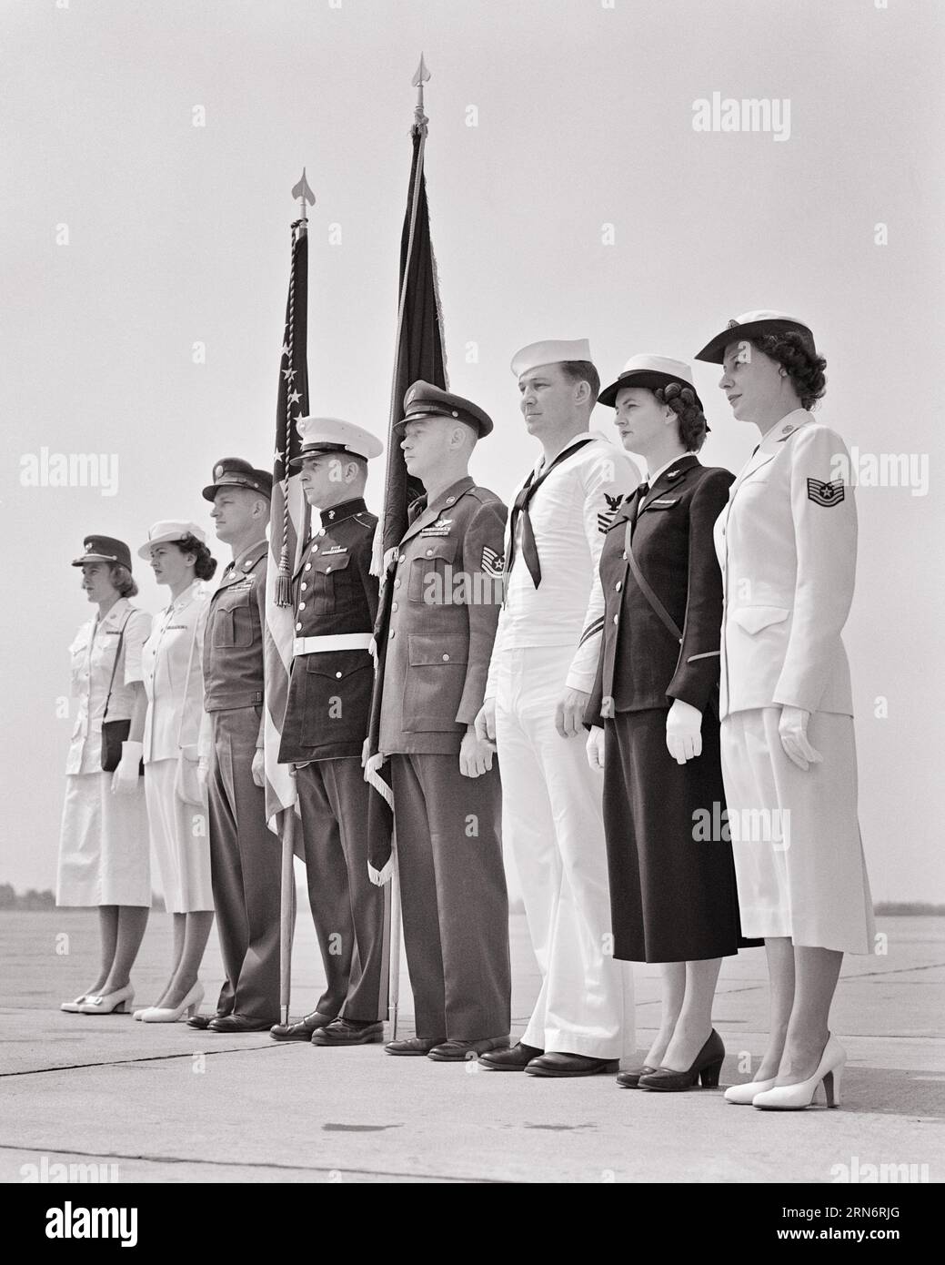 1950ER JAHRE MÄNNER FRAUEN IN DEN VERSCHIEDENEN UNIFORMEN DER US-ARMEE NAVY MARINES AIR FORCE MIT FLAGGEN STEHEND - M3781 HAR001 HARS NAVY HEALTHINESS UNITED STATES COPY SPACE FULL-LENGTH LADIES PERSONS INSPIRATION UNITED STATES OF AMERICA MÄNNER FORCE SELBSTVERTRAUEN B&W NORTH AMERICA FREEDOM NORTH AMERICAN 8 ADVENTURE PROTECTION LEADERSHIP LOW ANGLE PRIDE OPPORTUNITY MARINES BERUFE PATRIOT UNIFORMEN FARBE GUARD KONZEPTIONELLE PATRIOTISCHE STARS UND STREIFEN STILVOLLE UNTERSTÜTZUNG VERSCHIEDENE ZUSAMMENARBEIT ACHT PATRIOTISMUS ROT WEISS UND BLAU JUNGE ERWACHSENE MANN JUNG ERWACHSENE FRAU SCHWARZ-WEISS Stockfoto