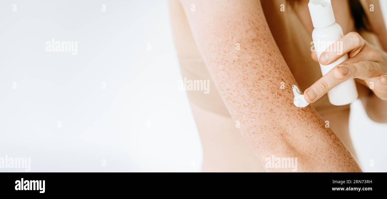 Banner einer Frau, die Creme auf ihren Körper aufträgt, Hautschutz vor der Sonne, Hautfeuchtigkeit, Hautpflege nach Dusche und Bad, Behandlung. Gebräunte Haut mit Stockfoto