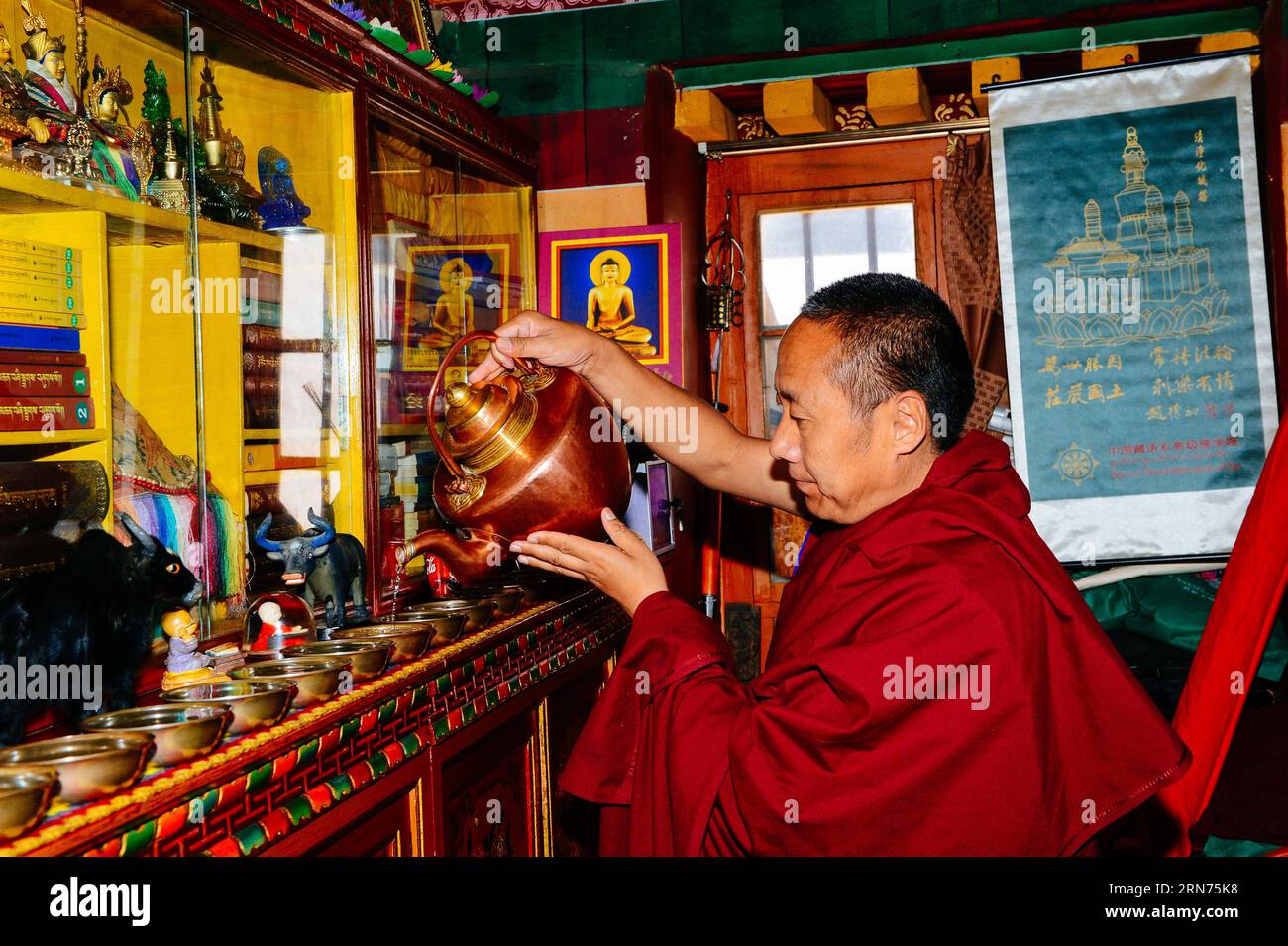 (150818) -- LHASA, 18. August 2015 -- Nyima Tsering gießt heiliges Wasser zur Anbetung in sein Zimmer im Jokhang-Tempel in Lhasa, Hauptstadt der autonomen Region Tibet im Südwesten Chinas, 16. August 2015. Der 48-jährige Mönch Nyima Tsering beherrscht Chinesisch und Englisch. Nach dem Abschluss des High-Level Tibetan Buddhism College in Peking übernahm Nyima Tsering den Empfang im Verwaltungsausschuss des Jokhang-Tempels und stellte Touristen aus dem in- und Ausland Tempelinformationen als Reiseleiter vor. ) (xcf/mcg) CHINA-LHASA-REISELEITER-MÖNCH (CN) Chogo PUBLICATIONxNOTxINxCHN 150818 Lhasa 18. August 2015 Stockfoto