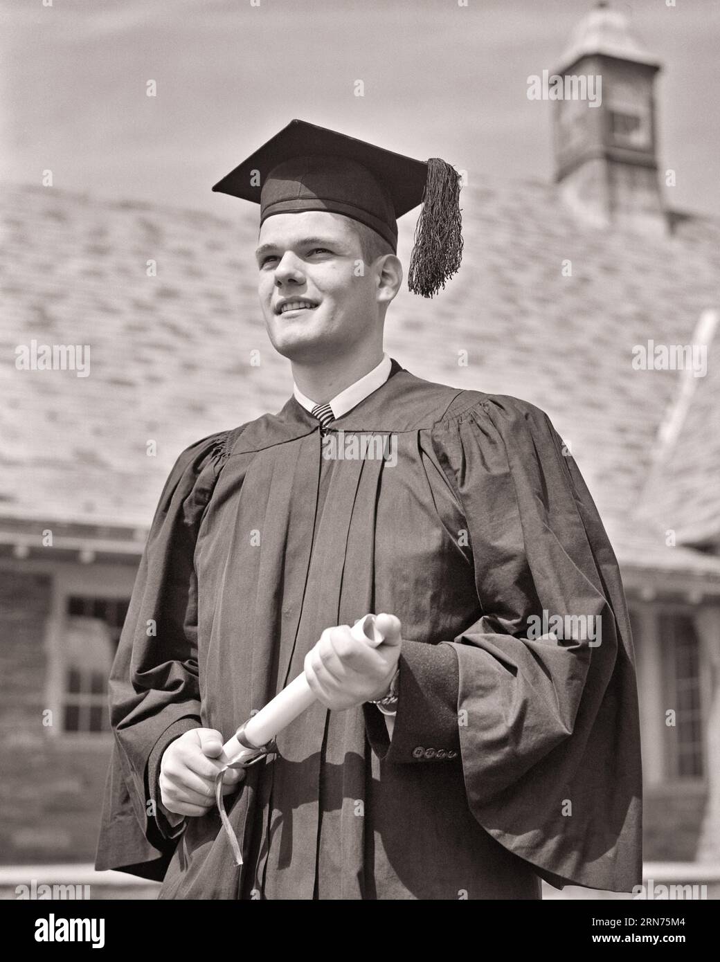 1950ER JAHRE HOCHSCHULABSCHLUSS MIT ABSCHLUSS IN CAP UND KITTEL MIT BLICK AUF DIE ZUKUNFT - S9159 HAR001 HARS SATISFACTION CELEBRATION READY DIPLOMA HEALTHINESS COPY SPACE HALF-LENGTH PERSONS INSPIRATION MÄNNER TEENAGER ABSCHLUSS SELBSTVERTRAUEN AUSDRÜCKE B&W ZIELE ERFOLG TRÄUME GLÜCK FRÖHLICH UNIVERSITÄTEN UND WISSEN NIEDRIGER WINKEL STOLZ GELEGENHEIT ZU ANTIZIPIEREN HIGHSCHOOL LÄCHELT HIGHSCHOOL HOCHSCHULBILDUNG FRÖHLICHE TEENAGER COLLEGES MORTARBOARD JUNGER ERWACHSENER MANN SCHWARZ-WEISS CAP UND KITTEL KAUKASISCHE ETHNIZITÄT HAR001 ALTMODISCH Stockfoto