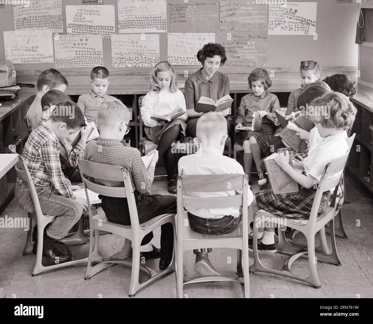 1960ER-JAHRE-GRUPPE VON GRUNDSCHÜLERN, DIE IM LESEKREIS MIT DEM LEHRER SITZEN - S12901 HAR001 HARS-KOPIENRAUM FÜR FRAUEN FREUNDSCHAFT HALBE LÄNGE DAMEN PERSONEN INSPIRATION MÄNNER SCHWARZWEISS-ZIELE SCHULEN KLASSE HIGH-ANGLE-ENTDECKUNG INSTRUKTOR FÜHRUNG FORTSCHRITT CHANCEN BERUFE PRIMÄRE KONZEPTIONELLE PÄDAGOGE K-12 ZUSAMMENARBEIT PÄDAGOGEN BILDUNGSLEHRER SCHULWACHSTUMSLEHRER JUGENDLICHE SCHULE UNTERRICHTET ZWEISAMKEIT JUNGE ERWACHSENE FRAU SCHWARZ-WEISS KAUKASIER ETHNIZITÄT HAR001 ALTMODISCH Stockfoto