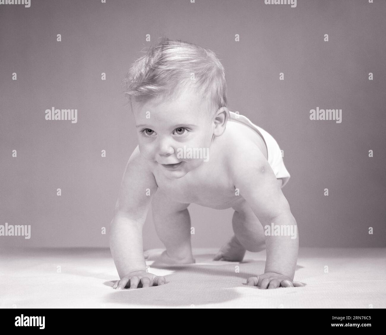 1960ER JAHRE BLONDES BABY, DAS AUF ALLEN VIEREN IN RICHTUNG KAMERA KRIECHT - B21684 HAR001 HARS FOURS GROWTH JUNGTIERE SCHWARZ-WEISS KAUKASISCHE ETHNIE HAR001 ALTMODISCH Stockfoto