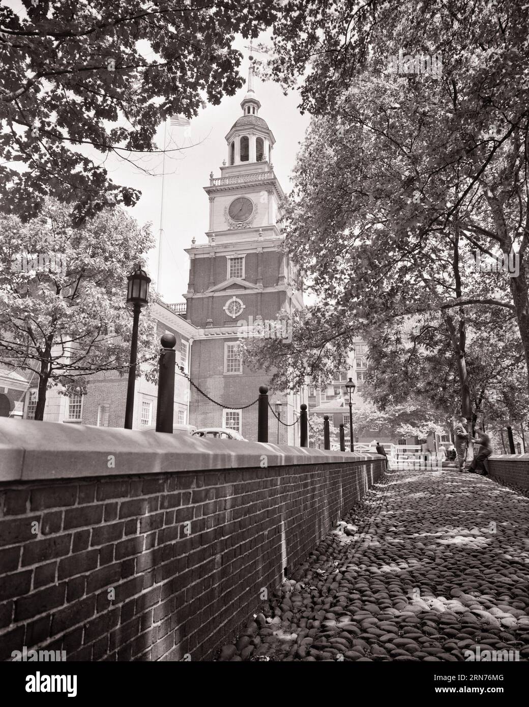 1950ER JAHRE SCHATTIGER KOPFSTEINPFLASTERGANG HINTER DER UNABHÄNGIGKEITSHALLE PHILADELPHIA PA USA - P3611 HAR001 HARS NATIONAL PARK SERVICE SCHWARZ-WEISSE STADT DER BRÜDERLICHEN LIEBE KONTINENTALER KONGRESS UNABHÄNGIGKEITSERKLÄRUNG HAR001 UNABHÄNGIGKEITSHALLE ALTMODISCH Stockfoto