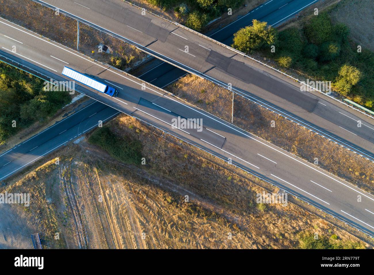 Luftaufnahme eines Autobahnabschnitts über eine Straße und eines Lkws, der darauf fährt. Stockfoto