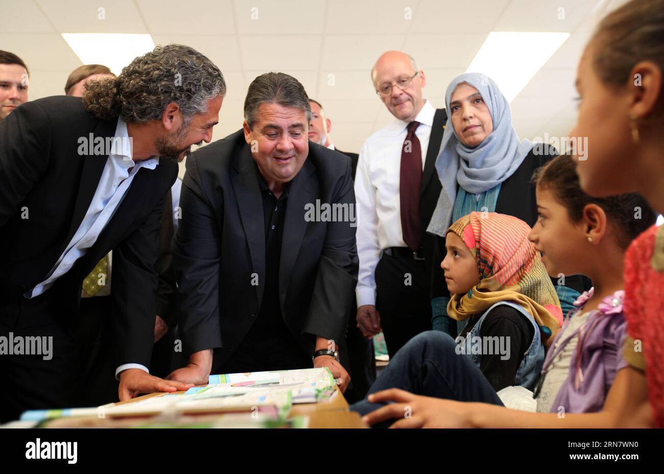 (150922) -- AMMAN, 22. September 2015 -- der deutsche Wirtschaftsminister Sigmar Gabriel (C) spricht während seines zweitägigen Besuchs im syrischen Flüchtlingslager Zattari nordöstlich von Amman, Jordanien, am 22. September 2015 mit Flüchtlingen. ) (DJJ) JORDANIEN-AMMAN-SYRISCHES FLÜCHTLINGSCAMP-DEUTSCHER WIRTSCHAFTSMINISTER-BESUCH MOHAMMADXABUXGHOSH PUBLICATIONXNOTXINXCHN Stockfoto