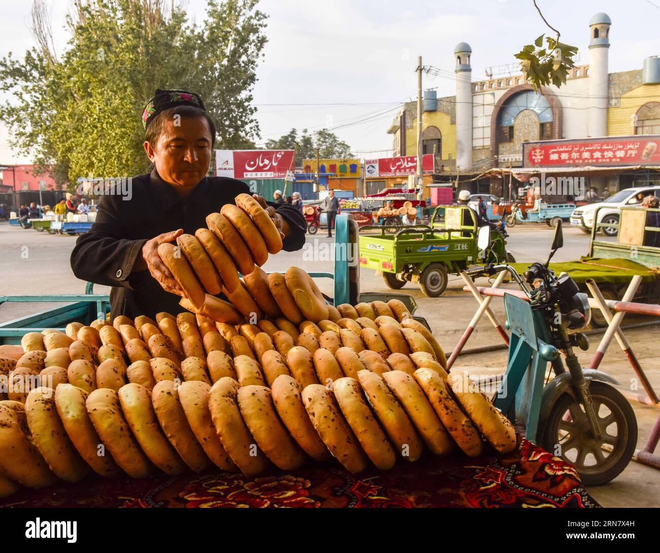 (150923) -- TURPAN, 23. September 2015 -- Foto aufgenommen am 16. September 2015 zeigt Abduweli Rozi, wie er nang, eine Art knuspriges Brot, für einen Verkäufer in Turpan, Nordwestchinas Autonome Region Xinjiang Uygur, platziert. Fast jeden frühen Morgen wachen der 45-jährige Abduweli Rozi und seine Frau vor 3 Uhr auf und beginnen ihre Arbeit. In den nächsten 10 Stunden machten sie 300 nang und verteilten sie an Verkäufer in der Stadt. Dies ist nur ein Teil der Geschichte, die jeden Tag in einer kooperativen Gruppe von nang-Machern in Turpan stattfand. Neben Abduweli Rozi's Famliy arbeiten bis jetzt 17 Familien auf einem Hof zusammen und halten sich an ein Stockfoto