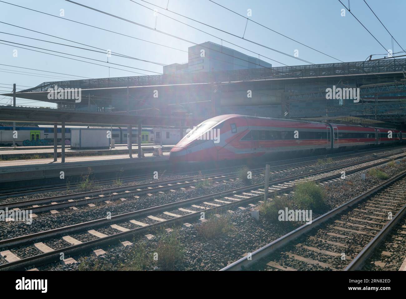 Bahnhof mit vielen Bahnsteigen fährt der Hochgeschwindigkeitszug auf den Bahnsteigen vorbei. Die Zahl der Urlaubs- und Arbeitsreisenden ist immer sehr hoch. Stockfoto