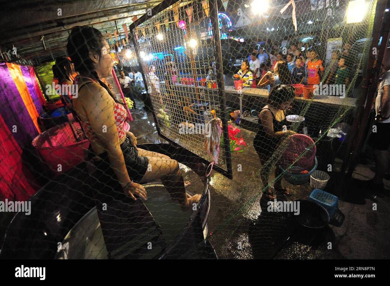 (151101) -- BANGKOK, 1. November 2015 -- Dunk Tank Girls sitzen hinter dem Netz in Bangkok, Thailand, 1. November 2015. Ein Wassertank besteht aus einem Wassertank, über dem ein Freiwilliger auf einem zusammenfallenden Sitz sitzt. Wenn ein Ball auf ein Ziel trifft, bricht der Sitz zusammen und taucht die Person ins Wasser. ) THAILAND-BANGKOK-DUNK TANK GIRL RachenxSageamsak PUBLICATIONxNOTxINxCHN Bangkok Nov 1 2015 Dunk Tank Girls sitzen hinter dem Netz in Bangkok Thai Country Nov 1 2015 ein Dunk Tank besteht aus einem Tank mit Wasser, über dem ein Freiwilliger AUF einem zusammenfallenden Sitz sitzt, wenn ein Ball AUF ein Ziel trifft der Sitz kollabiert und die Person int Stockfoto