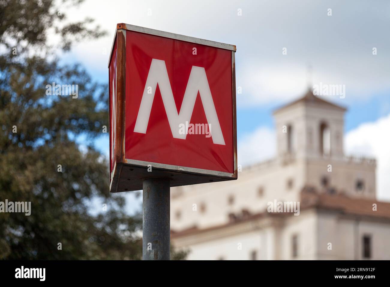 Nahaufnahme des Metro-Schilds von Rom vor dem Bahnhof Spagna, mit dahinter der Villa Medici. Stockfoto