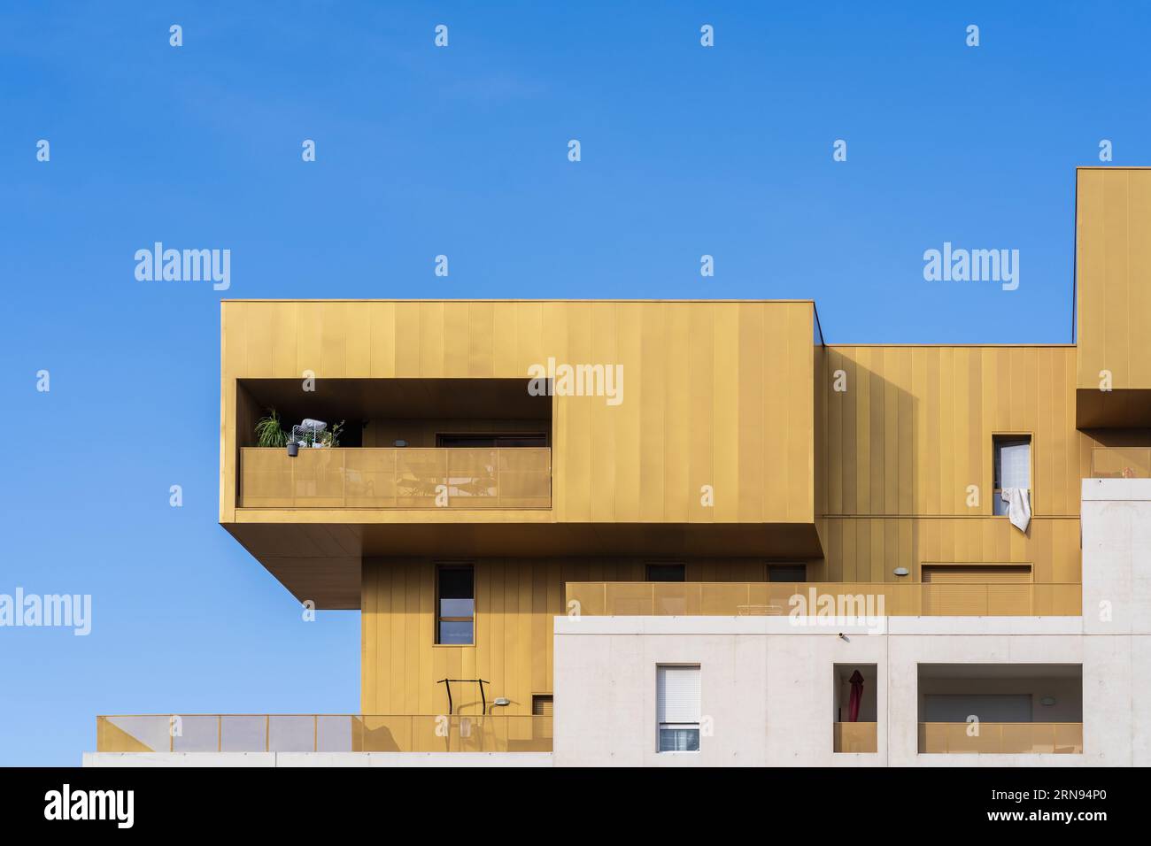 Montpellier, Frankreich - 08 28 2023 : Detailansicht des goldenen und weißen geometrischen Äußeren des Plaza Real Apartmentgebäudes mit zeitgenössischer Architektur Stockfoto