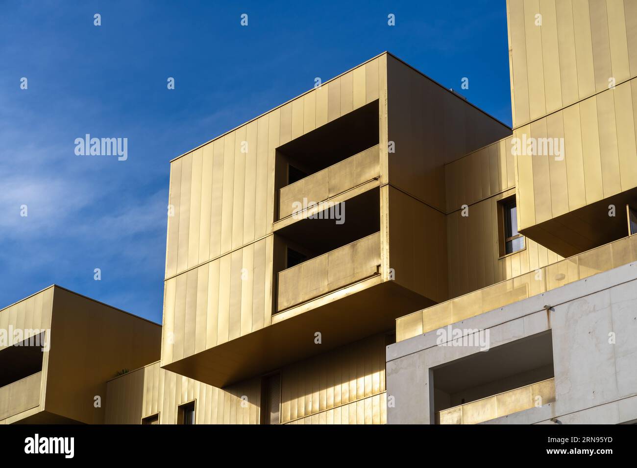 Montpellier, Frankreich - 08 28 2023 : Landschaftsblick auf die helle goldene geometrische Fassade des Plaza Real Apartmentgebäudes mit zeitgenössischer Architektur Stockfoto