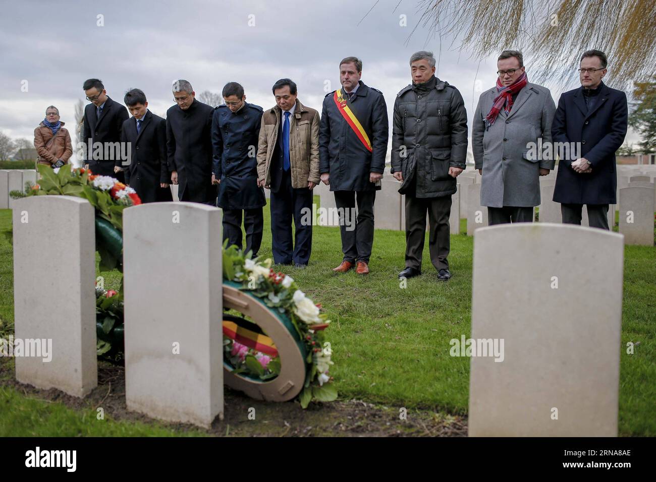 POPERINGE (BELGIEN), 12. Januar 2016 -- der chinesische Botschafter in Belgien Qu Xing (3., R) legt am 12. Januar 2016 auf dem Lijssenthoek Militärfriedhof in Poperinge, Belgien, einen Kranz auf die während des Ersten Weltkriegs verstorbenen chinesischen Arbeiter. Von den 140.000 chinesischen Arbeitskräften, die während des Ersten Weltkriegs für Kriegsdienstarbeiten nach Europa geschickt wurden, starben rund 20.000 Menschen und blieben aufgrund von Kriegsgewalt, mühsamer Arbeit und epidemischen Krankheiten verschollen. ) BELGIEN-POPERINGE-WELTKRIEG I-CHINESISCHE ARBEIT ZhouxLei PUBLICATIONxNOTxINxCHN POPERINGE Belgien 12. Januar 2016 Chinesischer Botschafter in Belgien Qu Xing 3. R. legt Wreath nach T Stockfoto