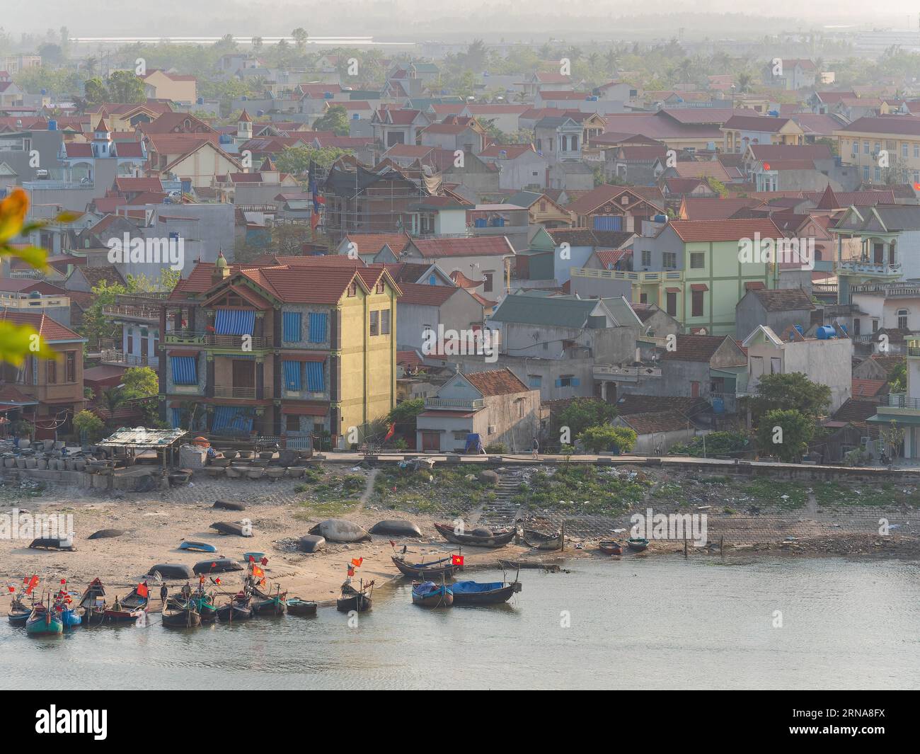 Hai Binh, ein Fischerdorf am Song Lach Bang River in der Provinz Thanh Hoa in Vietnam. Die Boote im Vordergrund sind hell beleuchtet, während die V Stockfoto