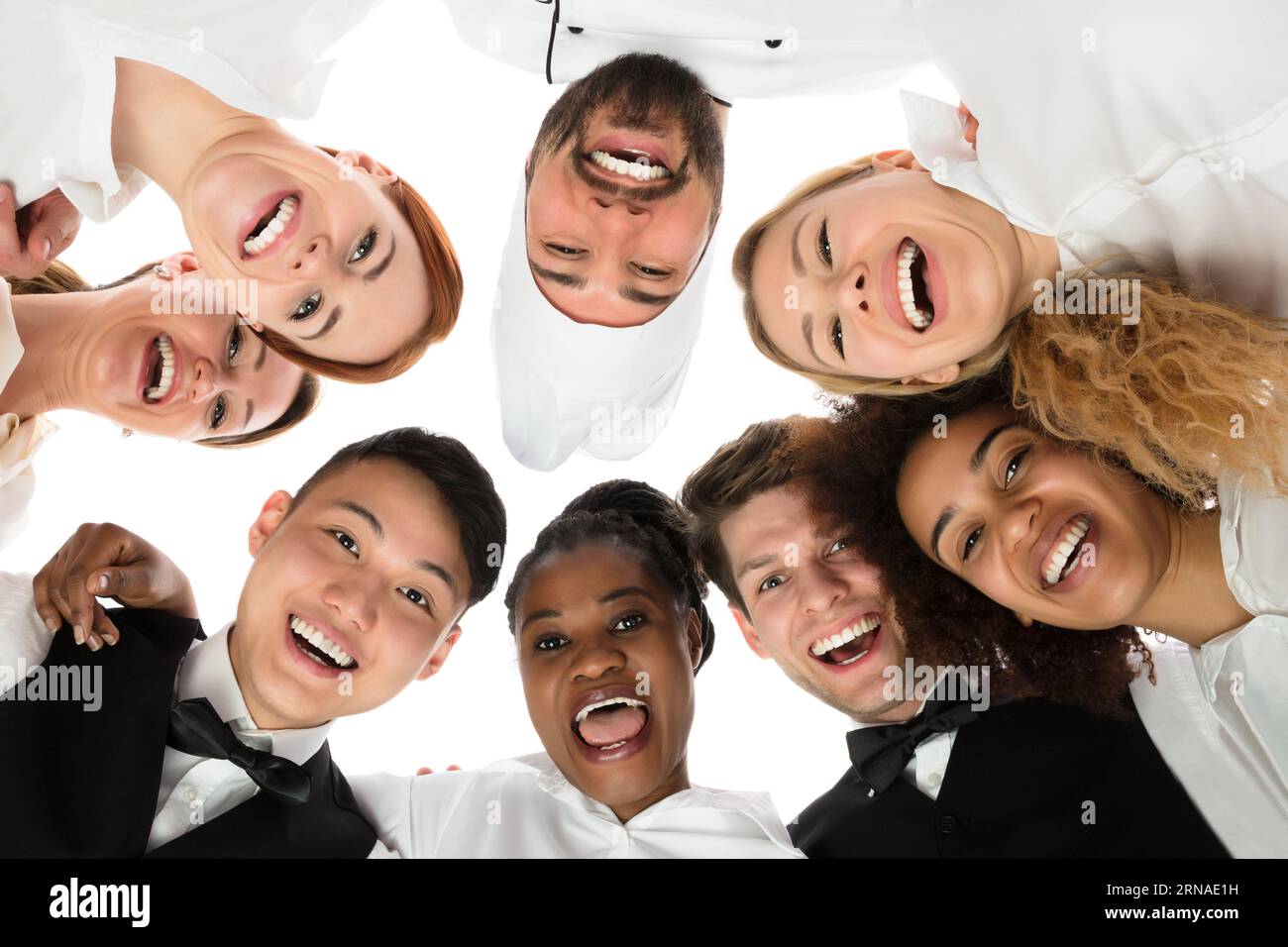 Low Angle View von glücklichen Angestellten im Restaurant vor weißem Hintergrund Stockfoto