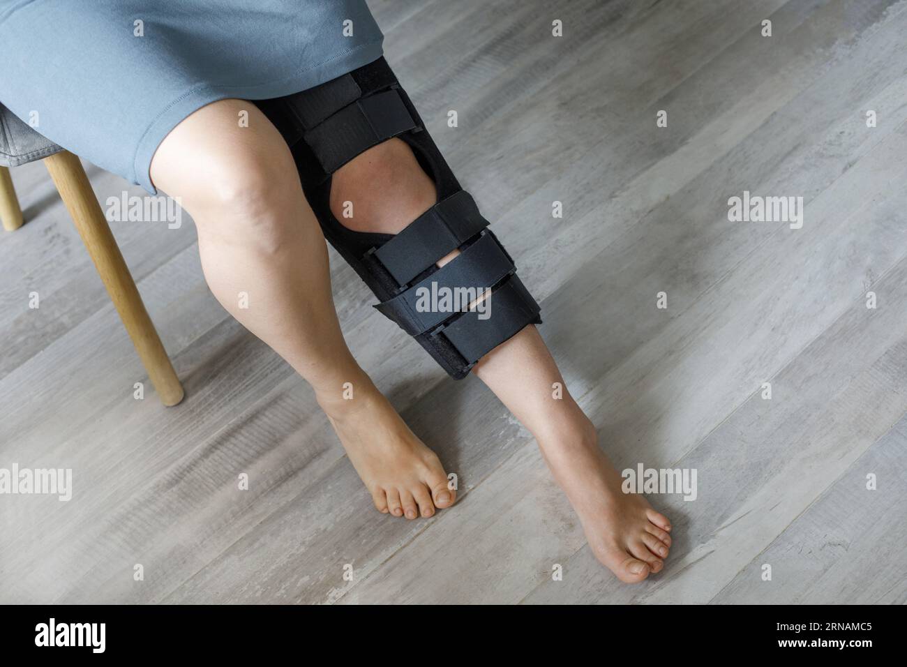 Das weibliche Bein trägt die Nahaufnahme einer Kniestrecke. Orthopädisch-Anatomische Orthesen. Zahnspangen zur Kniegelenkfixierung, Verletzungen und Schmerzen. Fussorthesen-Tutor Stockfoto