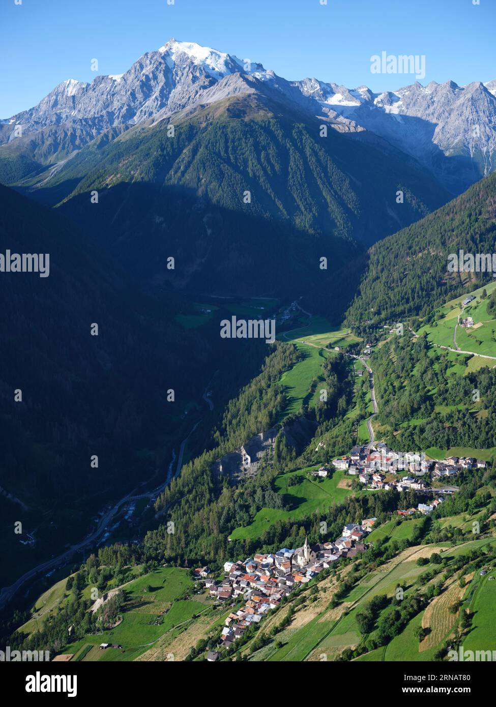 LUFTAUFNAHME. Stilfs, ein malerisches Dorf mit Ortles (3905 m) und seinem Gletscher für einen dramatischen Hintergrund. Trentino-Südtirol, Italien. Stockfoto