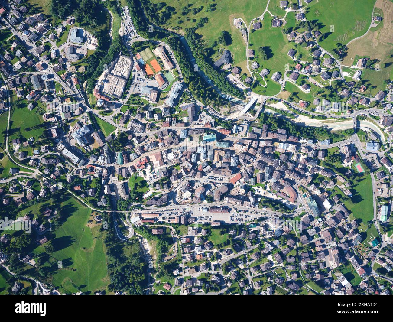 VERTIKALE LUFTAUFNAHME. Das Stadtzentrum von Cortina d'Ampezzo am linken Ufer des Flusses Boite. Provinz Belluno, Venetien, Italien. Stockfoto