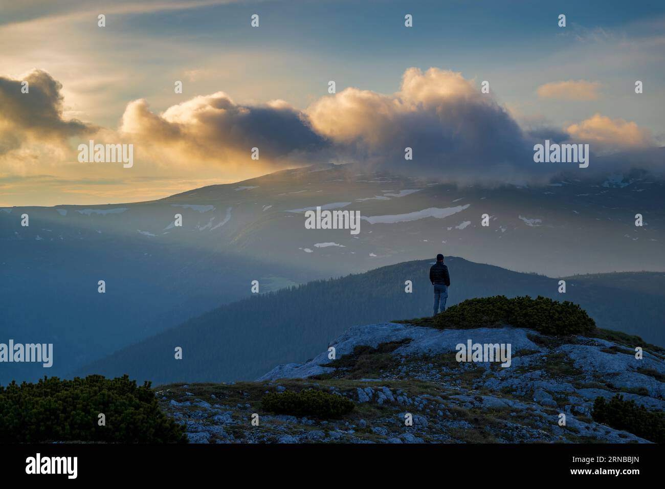 Mann im Sonnenuntergang auf dem Berg Stockfoto